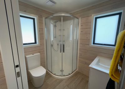 Bathroom with round front shower and cavity slider